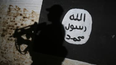 Un membre des forces irakiennes passe devant le logo de Daesh dans le village d'Albu Sayf, près de Mossoul en Irak, le 1er mars 2017.