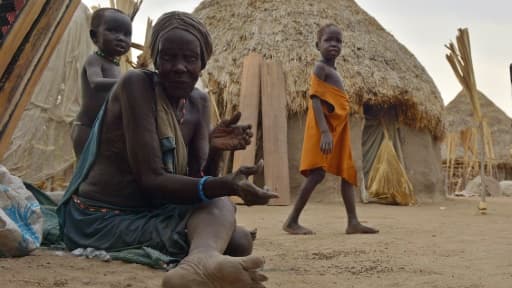 Une femme est assise sur le sol, devant des huttes dans la zone de Nyal, grande zone de marais dans l'Etat d'Unité, au Soudan du Sud souffrant de la famine, le 24 février 2015