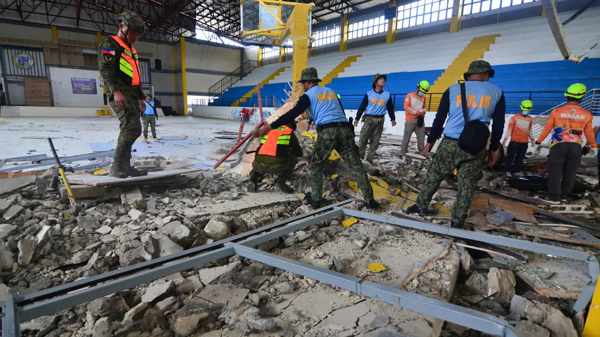     Police and rescuers inspect the damage to an Omnisport room in the city of San Remigio, in the province of Cebu, in the center of the Philippines, on October 1, 2025, after a powerful earthquake of magnitude 6.9. 