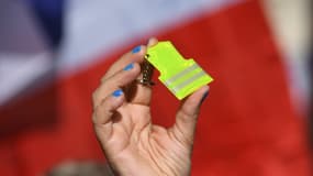 Une manifestante exhibe un porte-clé des gilets jaunes devant le Parlement, le 17 février 2020