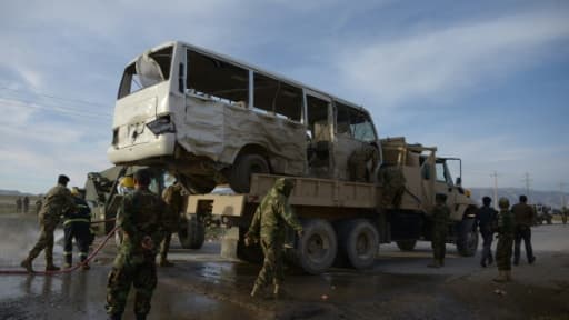 Des soldats afghans se tiennent près d'un bus contre lequel s'est jeté un kamikaze, tuant trois soldats, le 8 février 2016 à Dehdadi, dans l'agglomération de Mazar, en Afghanistan