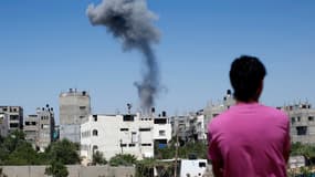 Un Palestinien regarde la fumée s'échappant d'un immeuble après une frappe israélienne sur Gaza, le 9 juillet 2014.