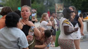 Des personnes se rafraîchissent en marchant dans une fine gerbe d'eau dans le centre de Paris le 21 juin 2025, lors d'une vague de chaleur. (Illsutration)