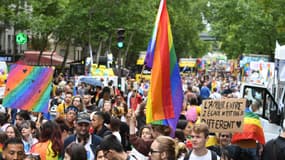 Des participants à la marche des fiertés à Paris brandissent le drapeau arc-en-ciel, le 25 juin 2022.