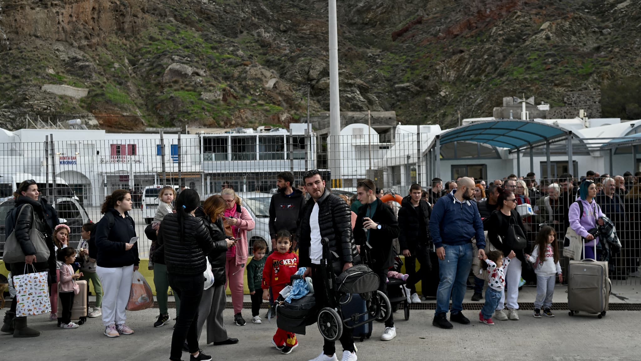 Des personnes attendent un ferry sur le quai du port de l'île grecque de Santorin, le 3 février 2025