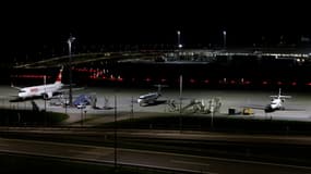 Une vue nocturne montre un avion de la compagnie aérienne Swiss parmi d'autres immobilisés à l'aéroport international de Munich, dans le sud de l'Allemagne, tôt le matin du 4 octobre 2025