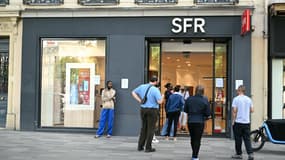 Des personnes se tiennent devant l'agence de l'opérateur de télécommunications français SFR à Paris, le 16 juin 2025.