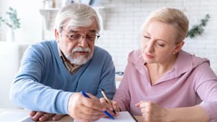 Un couple de retraités remplissant un document (photo d'illustration)