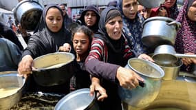 Des Palestiniens déplacés reçoivent de la soupe aux lentilles dans un centre de distribution alimentaire à Gaza City, dans le nord de la bande de Gaza, le 25 juillet 2025.