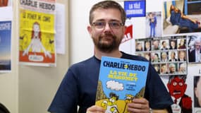 Charb, le directeur de Charlie Hebdo, montre la BD sur la vie de Mahomet qu'il s'apprête à publier.