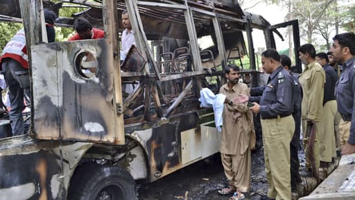 Les autorités sur les lieux de l'attentat visant un bus qui transportait majoritairement des étudiantes pakistanaises.