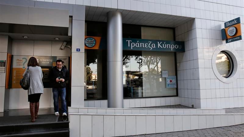 Devant un distributeur de billets à Nicosie. La France a haussé le ton mercredi contre Chypre, accusé d'avoir déclenché un vent de panique à travers l'Europe en décidant, contre l'avis du gouvernement français, de taxer les petits épargnants de l'île dans
