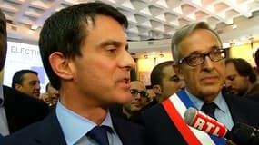 Manuel Valls, accompagné de Francis Chouat, son successeur à la mairie d'Evry, portant l'écharpe républicaine.
