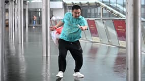 Un homme se protège contre les vents violents dans le district de Central alors que le typhon Wipha se déplace à proximité de Hong Kong le 20 juillet 2025.