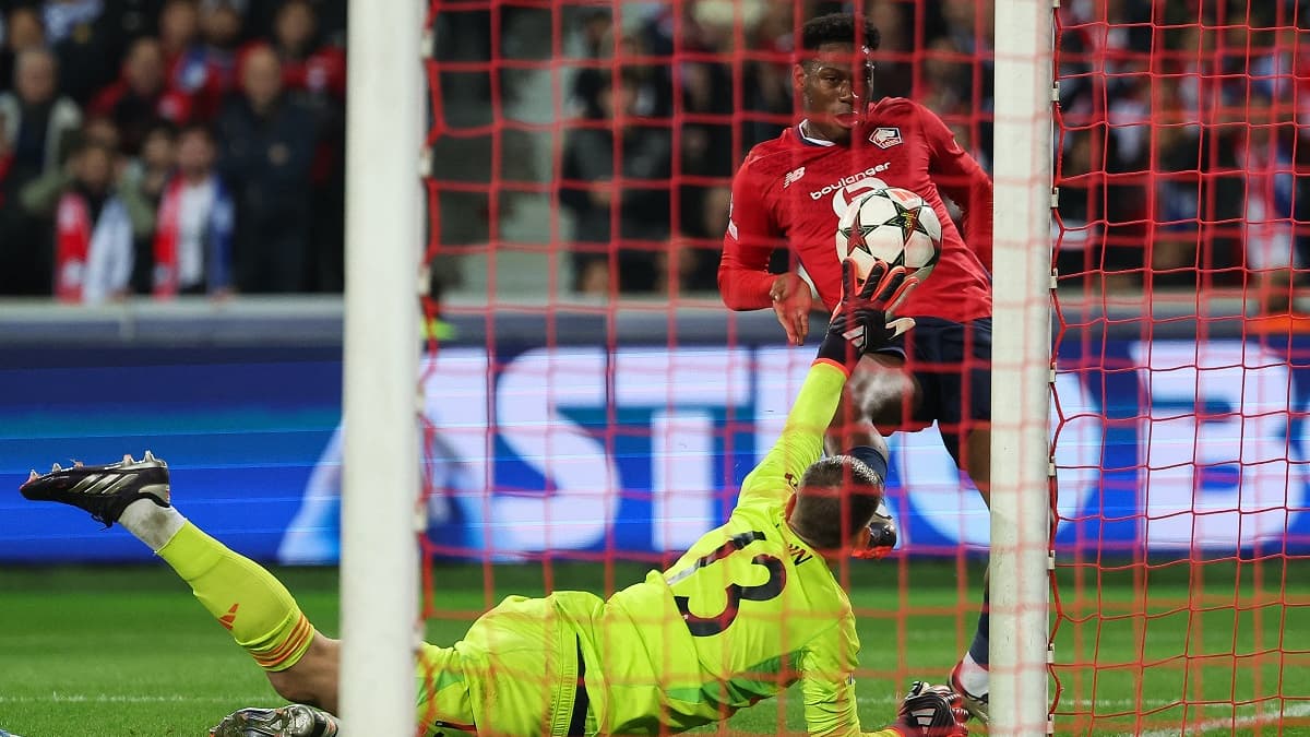 Le gardien du Real Madrid Lunin se relève très vite pour dévier la frappe de Jonathan David sur son poteau