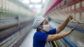 Une ouvrière travaille sur une chaîne de production intelligente dans une entreprise textile de Taizhou, province du Jiangsu, en Chine, le 17 décembre 2025. 