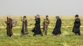 Des soldats des Forces Démocratiques Syriennes (FDS) encadrent des djihadistes à Baghouz, en Syrie, le 26 février 2019.