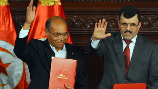 Le président tunisien Moncef Marzouki (gauche) et le Premier ministre islamiste sortant Ali Larayedh portent des copies de la nouvelle constitution le 27 janvier.