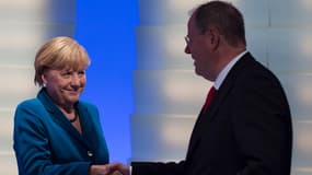 Angela Merkel serre la main à son rival Peer Steinbrück après sa victoire. Les deux partis, CDU et SPD, sont d'accord pour gouverner ensemble.