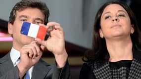 Arnaud Montebourg utilise son téléphone portable à côté de la ministre de l'Artisanat, du Commerce et du Tourisme Sylvia Pinel le 24 octobre 2013.