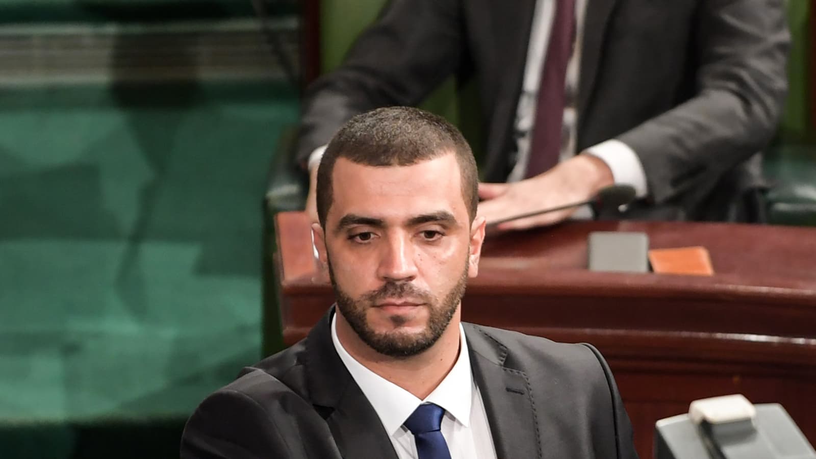 https://images.bfmtv.com/wDB-XNYWTccSLePmPDeUKQqzPdQ=/179x324:1987x1341/1600x0/images/Rached-Khiari-devant-lAssemblee-tunisienne-a-Tunis-le-8-decembre-2019-412700.jpg