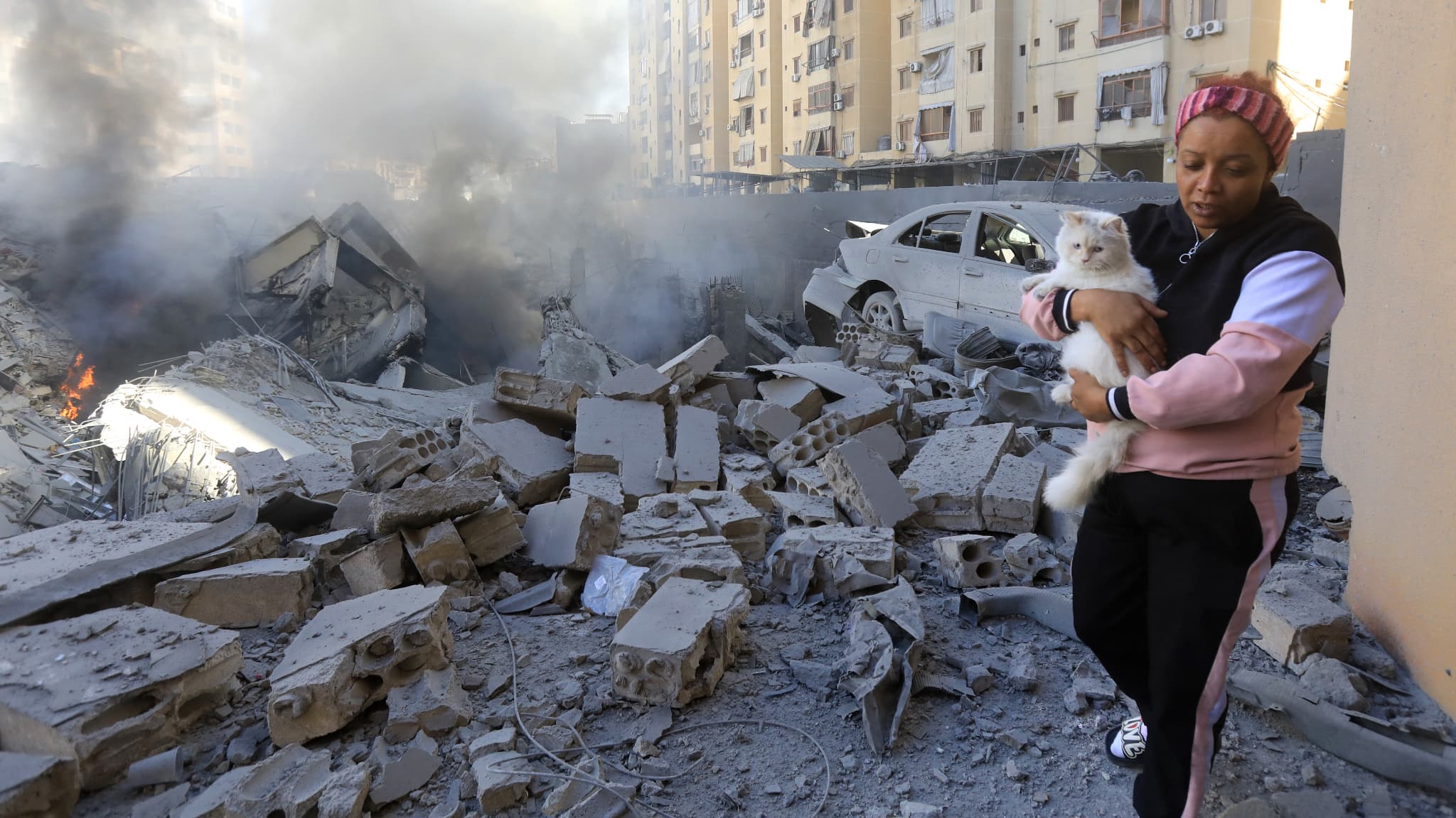Une femme porte un chat dans les décombres après des frappes israéliennes à Shayyah, dans la banlieue sud de Beyrouth, au Liban, le 2 octobre 2024