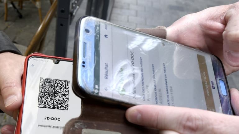 Un serveur vérifie le QR code du pass sanitaire d'un client à l'entrée d'un café, le 9 août 2021 à Valenciennes
