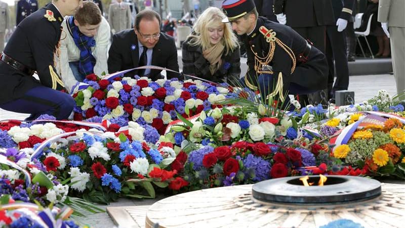 François Hollande, avec les enfants de militaires français morts cette année en Afghanistan, dépose une gerbe sous l'Arc de Triomphe, devant la tome du soldat inconnu. François Hollande a présidé pour la première fois dimanche à Paris les cérémonies commé