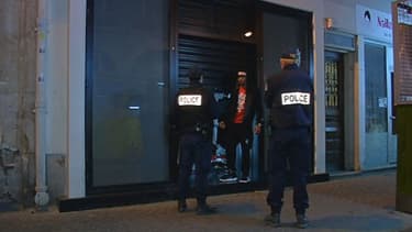 Des policiers devant la boutique où a eu lieu l'agression, dimanche soir.