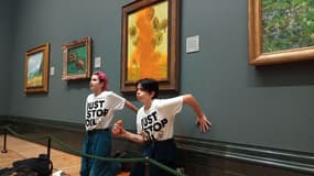 Des activistes de "Just Stop Oil" les mains collées au mur sous les "Tournesols" de Vincent Vermeeran Gogh après avoir jeté de la soupe à la tomate sur le tableau à la National Gallery, dans le centre de Londres, le 14 octobre 2022.