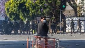 Un manifestant se tient devant la patrouille frontalière américaine après que des manifestants se soient affrontés lors d'un raid mené par les services de l'immigration et des douanes près d'un Home Depot, le 7 juin 2025 à Paramount, en Californie.