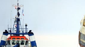 Photo prise le 13 juillet 2004 à Brest, de l'épave du chalutier breton Bugaled Breizh, posée sur une barge et tirée par un remorqueur de haute mer, se dirigeant vers le port militaire de Brest afin d'être mis en cale sèche pour être expertisée. 