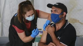Un homme reçoit une dose de vaccin anti-Covid dans le camp de réfugiés de Mavrovouni, sur l'île grecque de Lesbos, le 3 juin 2021