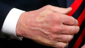 La trace blanche du pouce d'Emmanuel Macron apparaît sur la main de Donald Trump, après une poignée de mains au sommet du G7 à La Malbaie le 8 juin 2018