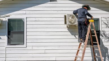 Un employé répare une unité de climatisation le 10 juillet 2023 à Austin, Texas, aux États-Unis.