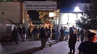 Des proches des victimes des attentats à la bombe qui ont tué au moins 12 personnes en Afghanistan, devant l'hôpital de Mazar-i-Sharif, le 25 mai 2022