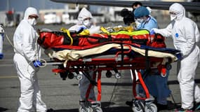 Le personnel médical transporte un patient infecté par le Covid-19 qui a été transféré de Nice, où les unités de soins intensifs sont surchargées, le 16 mars 2021 à Toulouse-Blagnac