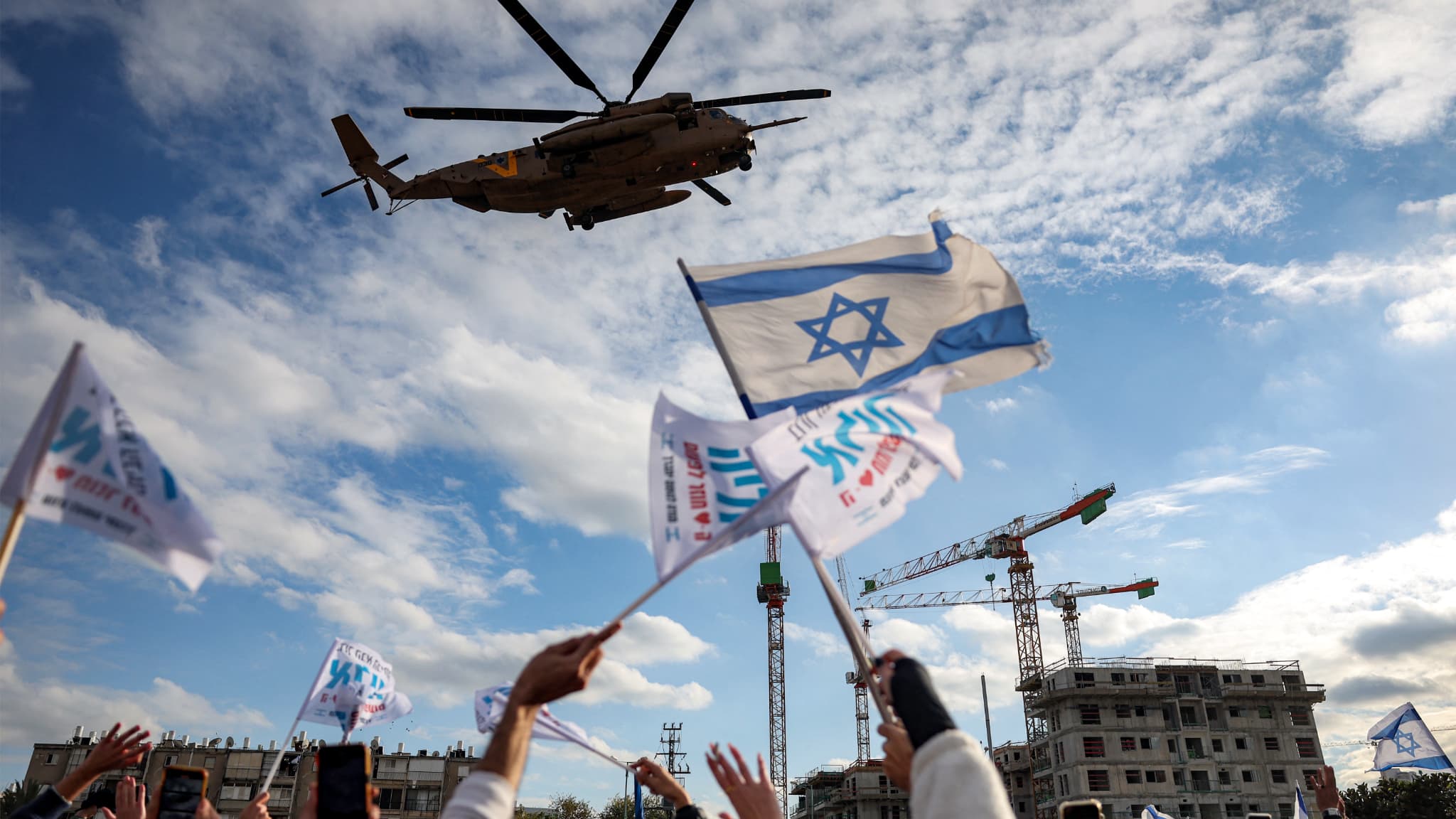 Des personnes acclament un hélicoptère de transport militaire CH-53 de l'armée de l'air israélienne transportant les otages israéliens récemment libérés Omer Shem Tov et Eliya Cohen à l'hôpital Beilinson du centre médical Rabin à Petah Tikva, dans le centre d'Israël, le 22 février 2025. (Photo d'illustration)