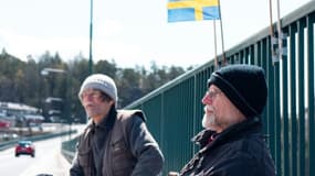 Pontus Berglund (g) et son frère jumeau Ola bavardent, l'un en Suède, l'autre en Norvège, sur le pont reliant les deux pays, le 1er mai 2021 à Svinesund