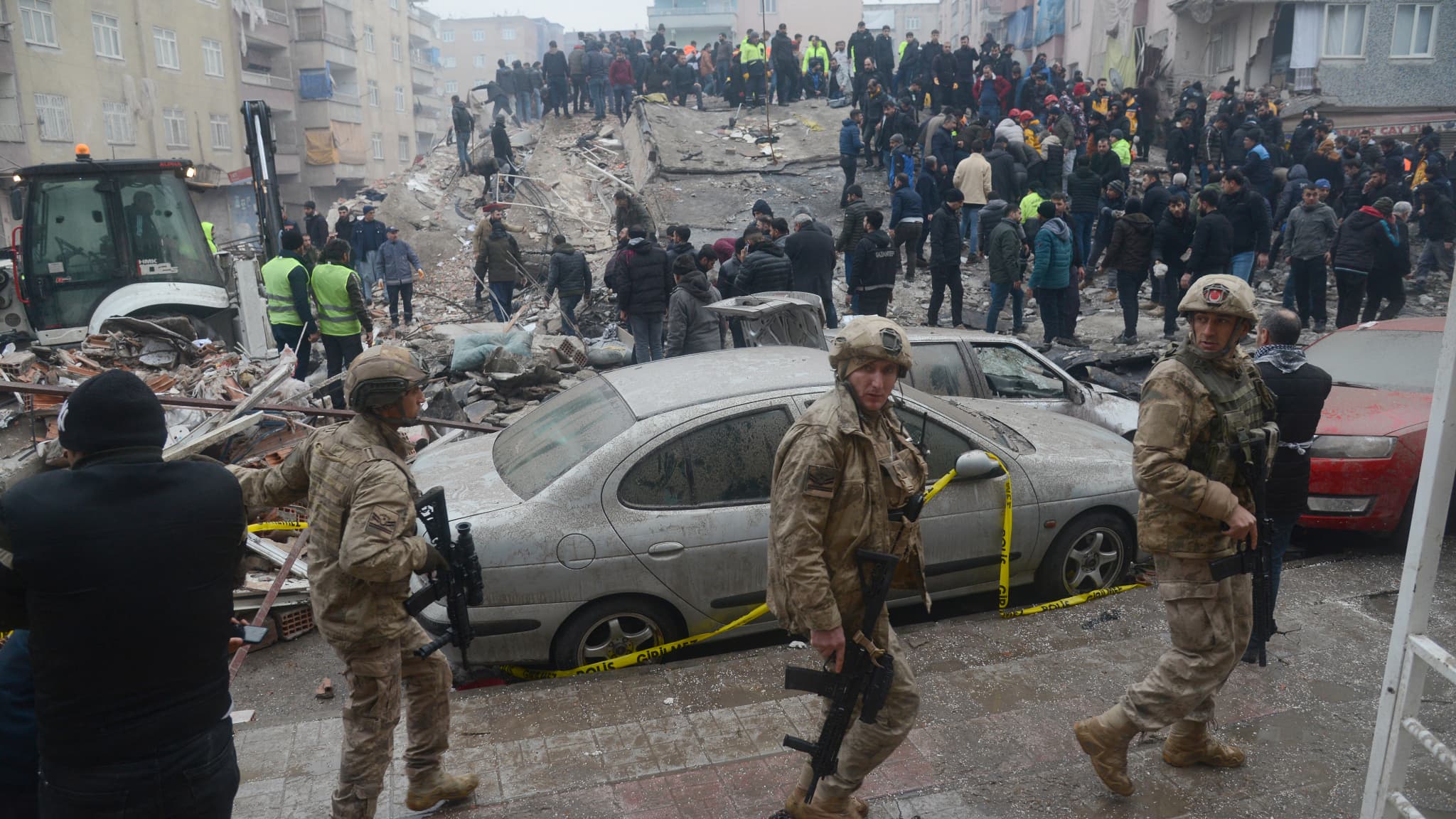 Des soldats marchent pendant que des personnes cherchent des survivants dans les décombres à Diyarbakir, le 6 février 2023, après qu'un tremblement de terre de magnitude 7.8 ait frappé le sud-est du pays. Des soldats marchent pendant que des personnes cherchent des survivants dans les décombres à Diyarbakir, le 6 février 2023, après qu'un tremblement de terre de magnitude 7.8 ait frappé le sud-est du pays.