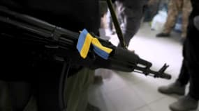 Un Ukrainien contrôle un check-point à Kiev, dimanche 6 mars 2022, et se prépare à l'assaut russe