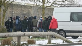 Des migrants font la queue devant un stand de distribution de nourriture à Calais le 8 février 2021