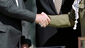 Yitzhak Rabin et Yasser Arafat, aux côtés de Bill Clinton, se serrent la main pour marquer leur rapprochement au moment des accords d'Oslo en septembre 1993. 