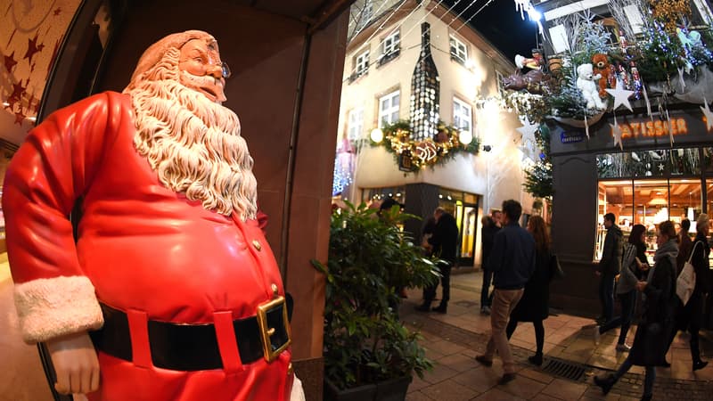 Une statue de père Noël dans une rue piétonne.