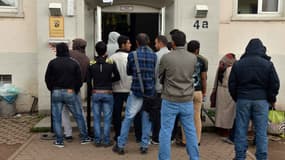 Des réfugiés font la queue devant un centre d'enregistrement de demandes d'asile, à Trier, en Allemagne, le 18 août 2015.