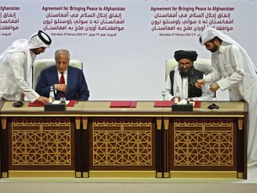 Le représentant des Etats-Unis pour la paix en Afghanistan, Zalmay Khalilzad, et le chef militaire afghan Mullah Abdul Ghani Baradar signent un accord de paix à Doha, au Qatar, le 29 février 2020