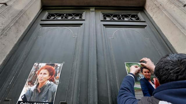 Un homme affiche des portraits des militantes kurdes assassinées dans la nuit du 9 au 10 janvier, au Centre d'information du Kurdistan, à Paris.