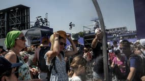 Des spectateurs se rafraichissent sur le site de la Concorde aux Jeux olympiques de Paris le 30 juillet 2024