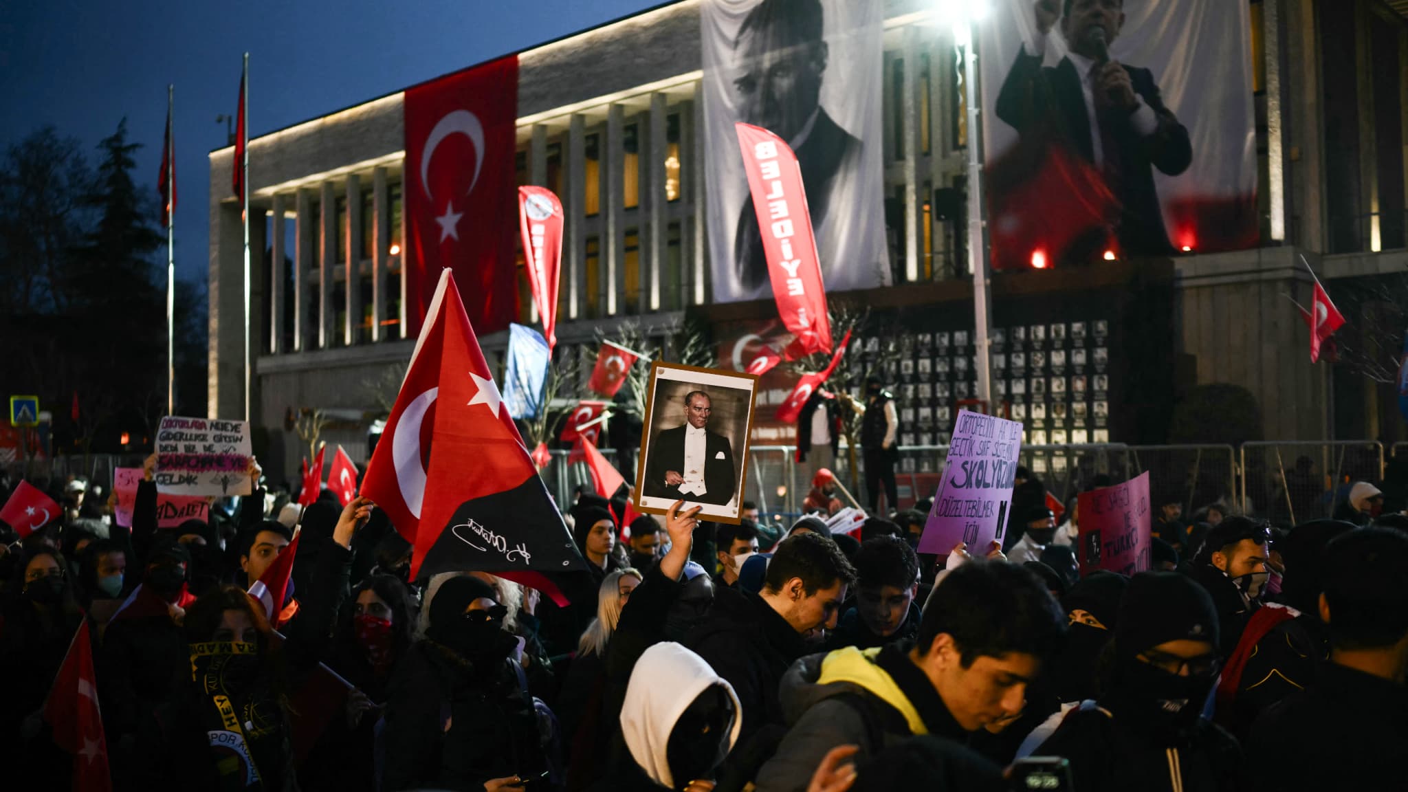 Un manifestant tient une photo du père fondateur de l'État moderne turc, Mustafa Kemal Ataturk, à côté de drapeaux turcs lors d'un rassemblement de soutien au maire arrêté d'Istanbul à l'hôtel de ville d'Istanbul (Turquie), le 24 mars 2025.