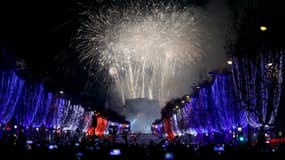 Des gens se rassemblent sur les Champs-Élysées pour assister au feu d'artifice et aux jeux de lumière lors des célébrations du Nouvel An à Paris, en France, le 1er janvier 2026.